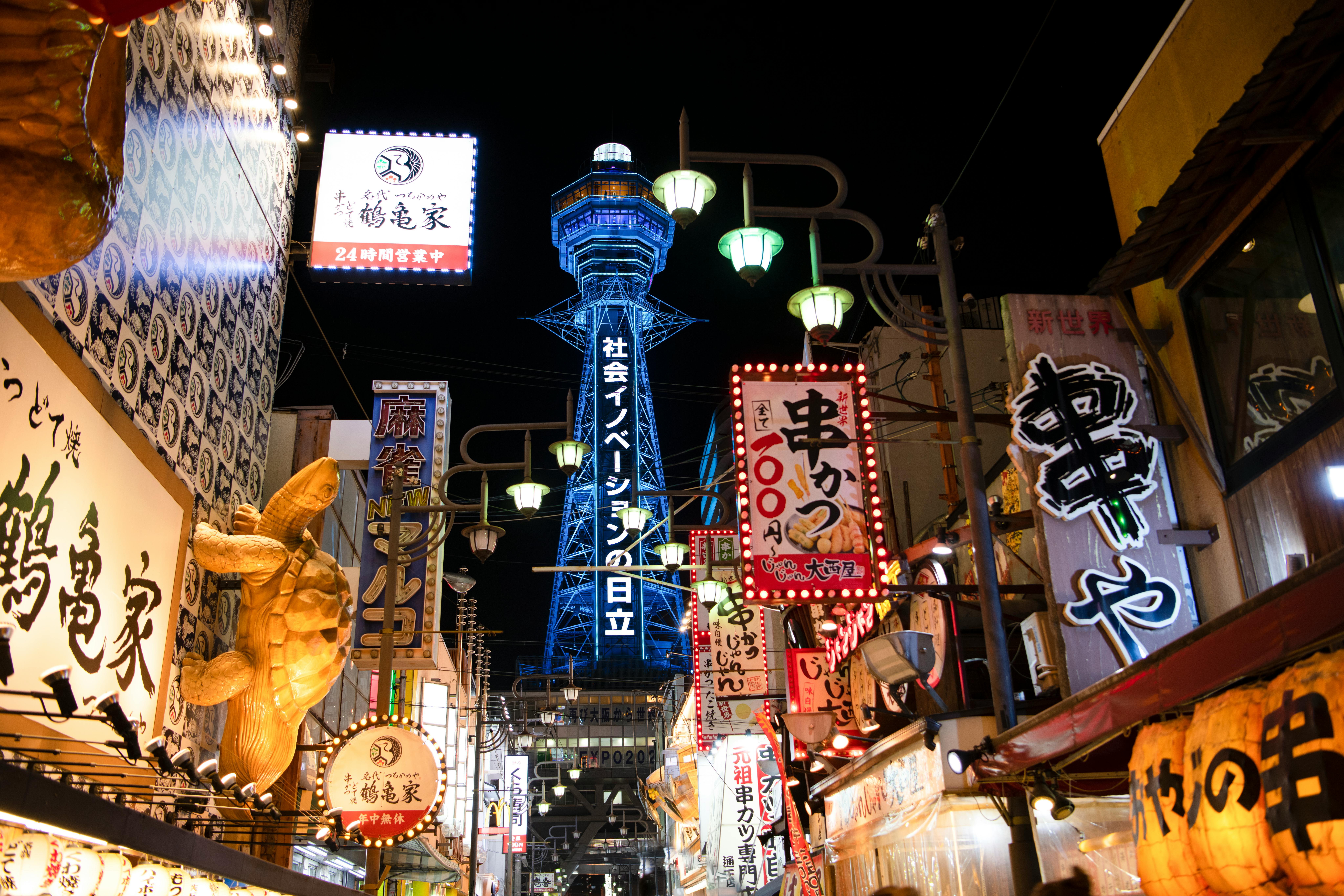 Osaka Shinsekai street with Tsutenkaku tower lit up at night